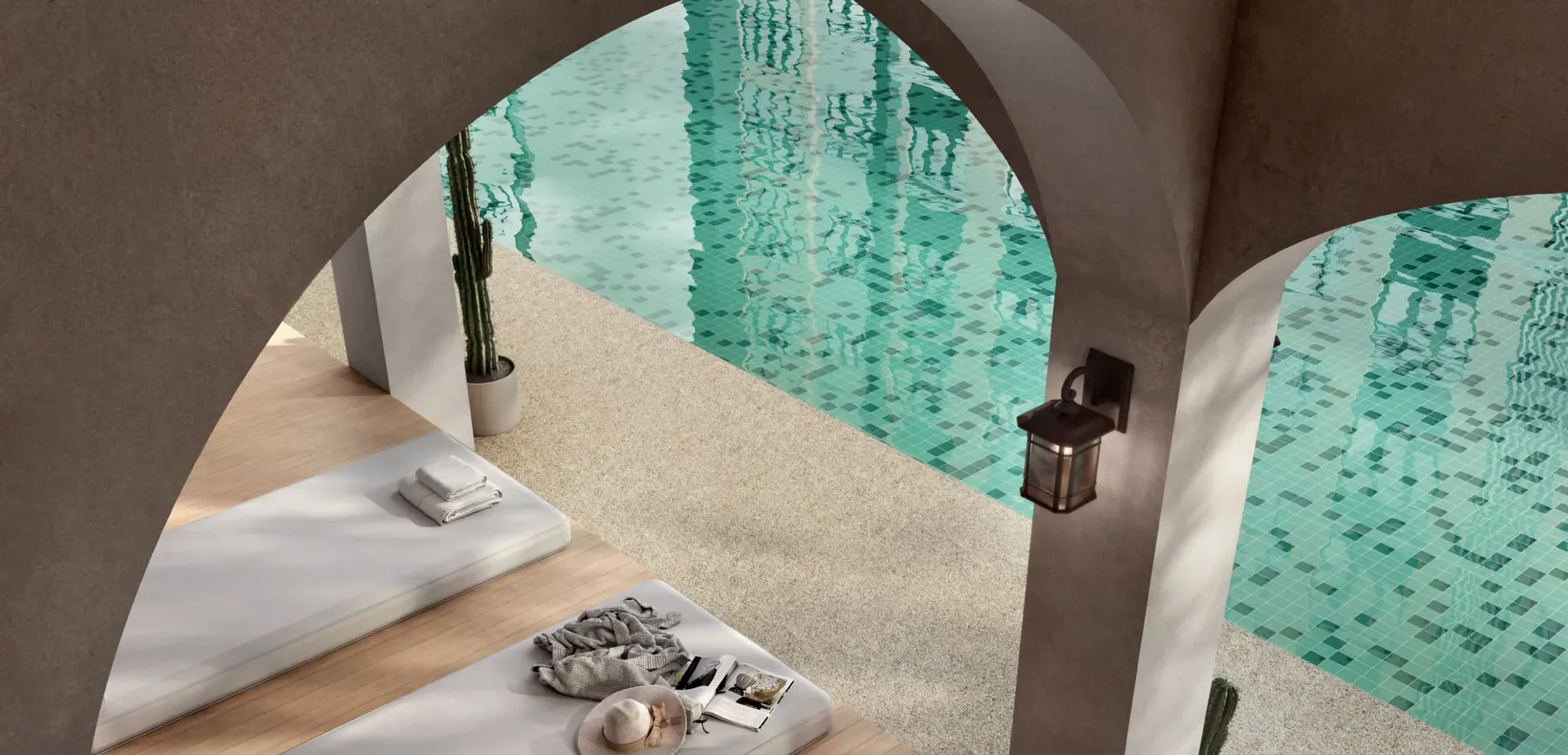Arched colonnade beside a mosaic-tiled pool at Tamu Residences